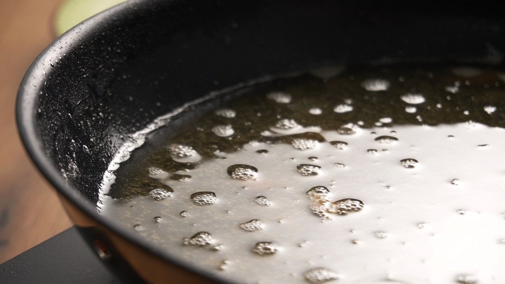 Dispose Of Kitchen Grease & Oil. Used Cooking Oil in Frying Pan with bubbles.