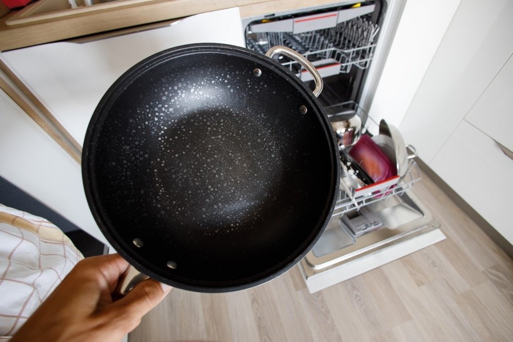 Hard Water. frying pan with white flakes from hard water while washing in the dishwasher in a modern kitchen.