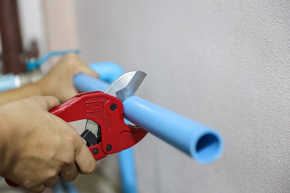 Need Poly B Pipe Repairs? Discover Aquality's Solutions. Plumbers are using pipe cutters to cut Poly B pipes to repair water are leaking, dripping, or installing water pump connections in the home.