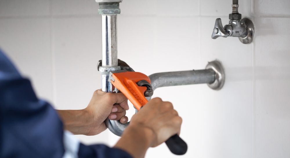 Why Are Aquality’s Calgary Plumbers Experts in Leak Repairs. plumber at work in a bathroom, plumbing repair service, assemble and install concept.