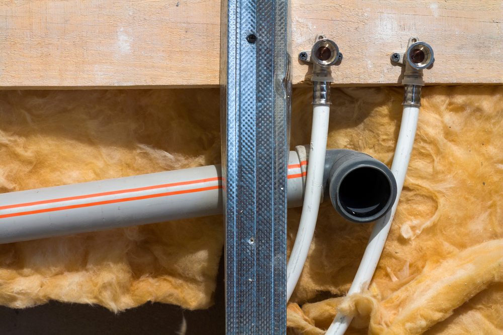 Understanding Poly B Plumbing: Risks & Repair Options in Calgary. Water pipes made of polypropylene in the wall, plumbing in the house. interior during renovation work. replacing Poly B pipes.