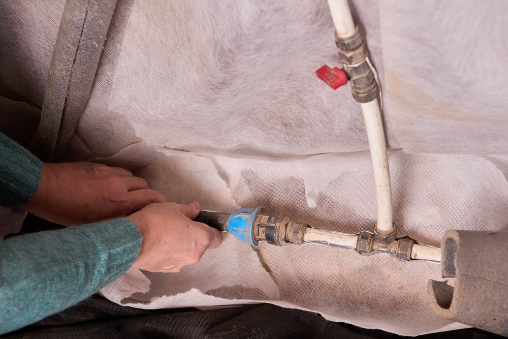 Understanding Poly B Plumbing: Risks & Repair Options in Calgary. Removing Poly B pipes in the basement of a rural house on the eve of winter frosts.