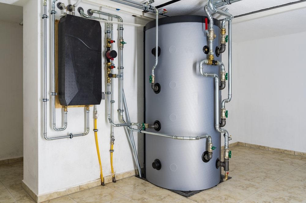 Modern,Buffer,Tank,System,Connected,To,Air-to-water,Heat,Pump,For Hot Water Tank Maintenance Tips for Calgary Residents. Modern Buffer Tank System Connected to Air-to-Water Heat Pump for Efficient Home Heating and Hot Water Storage in a Residential Setting.